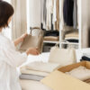 自宅で無地バッグと衣類を整理するイメージ