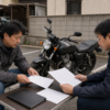 バイクの引き取り費用と契約条件を担当者と確認する所有者