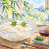 そうめんとつゆを夏の食卓に置き、背景に笹と短冊を描いたイラスト